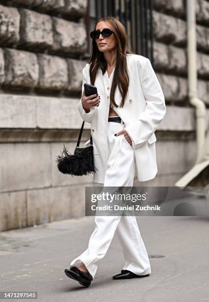 Chloe Harreuche is seen wearing a white jacket, white pants, black sunglasses and black bag outside the Hermes show during Paris Fashion Week F/W...