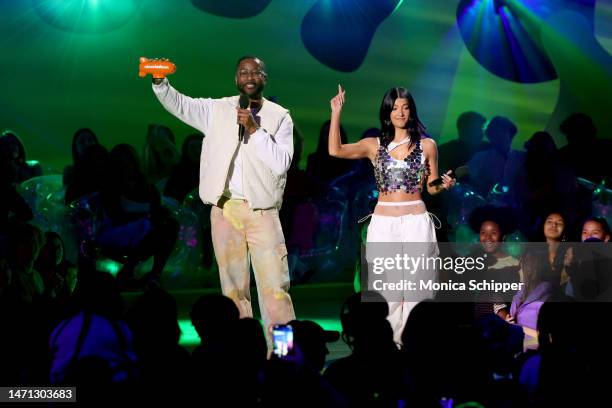 Nate Burleson and Charli D'Amelio speak onstage during the 2023 Nickelodeon Kids' Choice Awards at Microsoft Theater on March 04, 2023 in Los...