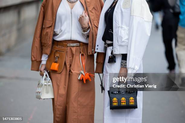 Twins wears Hermes bag, mini bag, brown wide leg pants, white jacket outside Hermes during Paris Fashion Week - Womenswear Fall Winter 2023 2024 :...