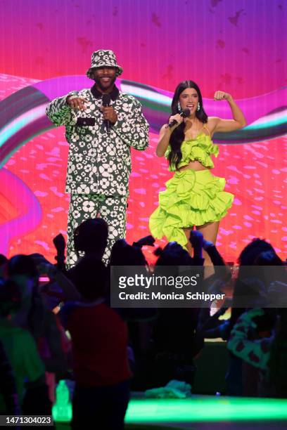 Nate Burleson and Charli D'Amelio speak onstage during the 2023 Nickelodeon Kids' Choice Awards at Microsoft Theater on March 04, 2023 in Los...