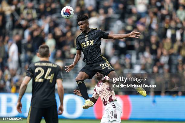 José Cifuentes of the Los Angeles FC jumps above Diego Chara of the Portland Timbers at midfield for a volley during a game between the Portland...