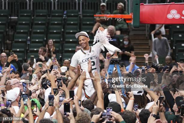 Isaiah Wong of the Miami Hurricanes cuts down the net after defeating the Pittsburgh Panthers 78-76 to win a share of the ACC Championship at Watsco...