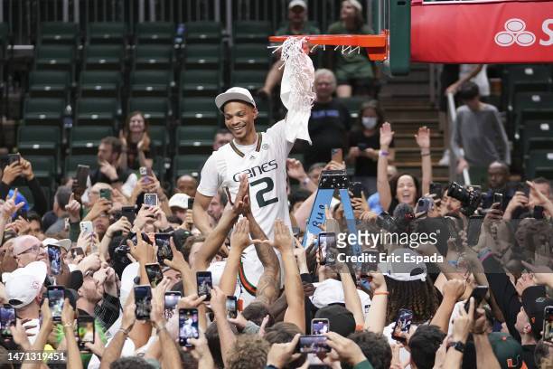 Isaiah Wong of the Miami Hurricanes cuts down the net after defeating the Pittsburgh Panthers 78-76 to win a share of the ACC Championship at Watsco...