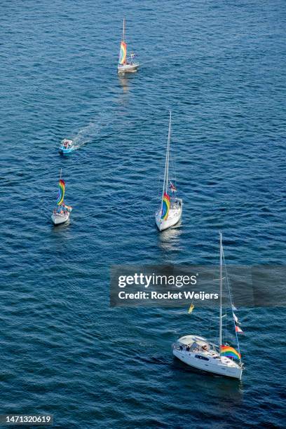 Boats on Sydney Harbour fly the Pride flag as they watch from below as people above take part in Pride March on the Harbour Bridge on March 05, 2023...