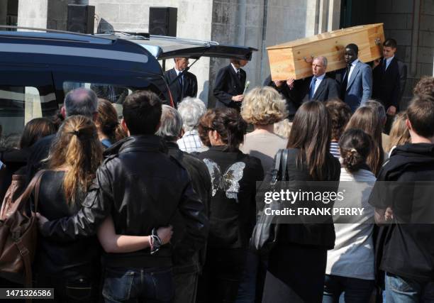 People stand outside the church of Saint Felix, in the French western city of Nantes, on April 28 as one of the five coffins is carried out, at the...