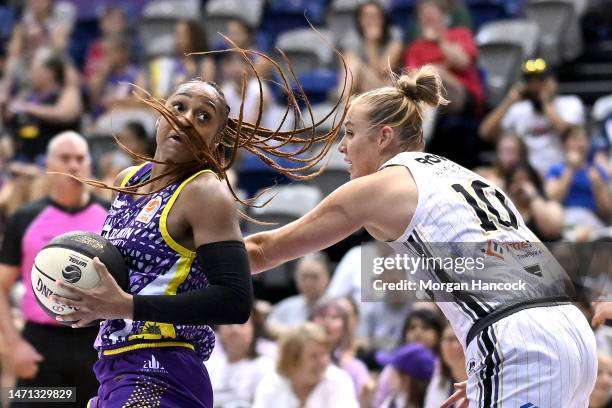 Kiera Rowe of the Flames attempts to defend as Tiffany Mitchell of the Boomers takes possession of the ball during the round 16 WNBL match between...