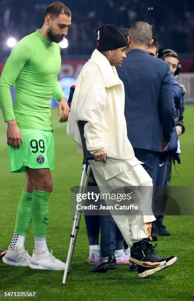 Goalkeeper Gianluigi Donnarumma, Neymar Jr of PSG on crutches during the trophy ceremony honoring Kylian Mbappe of PSG who scored its 201st goal for...