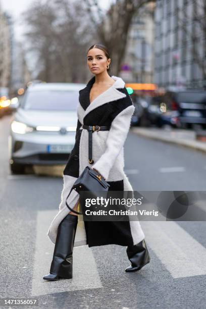 Olivia Culpo is seen wearing black white two tone belted coat, black Hermes bag, black boots during the Paris Fashion Week - Womenswear Fall Winter...