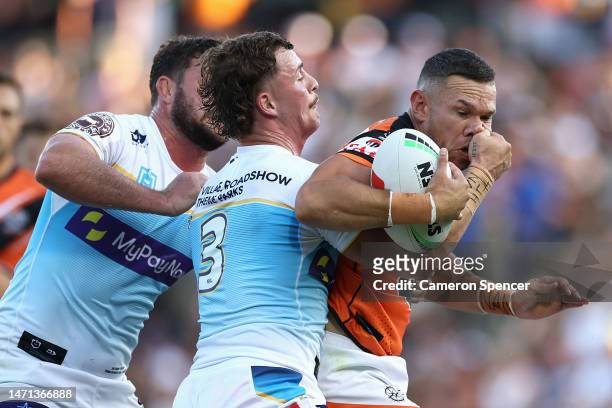 Brent Naden of the Wests Tigers is tackled during the round one NRL match between the Wests Tigers and the Gold Coast Titans at Leichhardt Oval on...