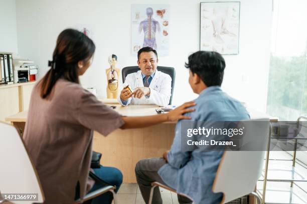 asian family with teenage boy visiting general practitioner, prescribing therapy for boy - doctor general practitioner stock pictures, royalty-free photos & images