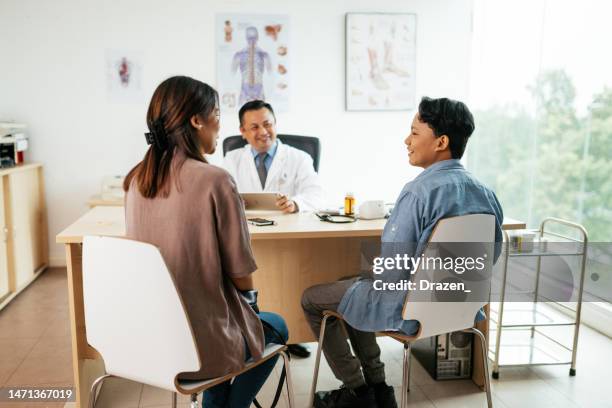 asian family with teenage boy visiting general practitioner due to fever and cough - doctor general practitioner stock pictures, royalty-free photos & images