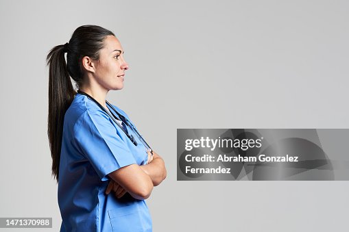 Side view of a nurse wearing a blue scrub looking forward to a copy space in a studio shot