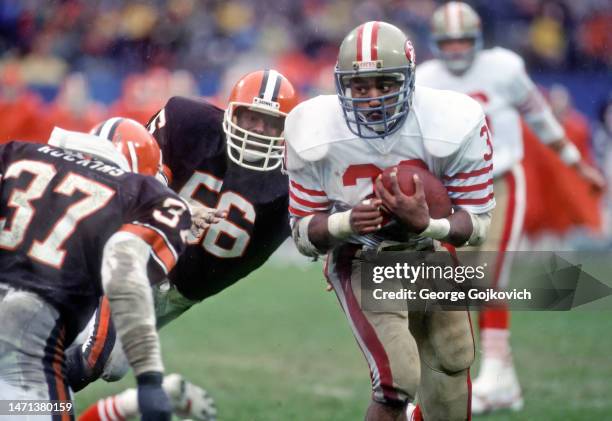 Running back Roger Craig of the San Francisco 49ers runs with the football as he is pursued by linebacker Chip Banks and safety Chris Rockins of the...