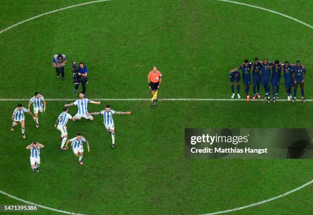 Lionel Messi of Argentina and his team mates celebrate the fourth and winning penalty by Gonzalo Montiel in the penalty shootout as France players...