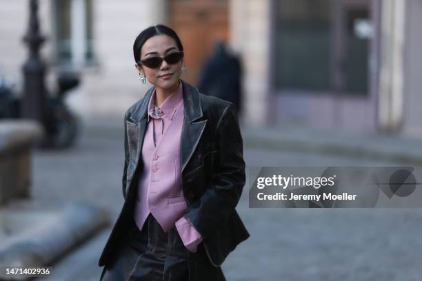 Yoyo Cao seen wearing a black leather blazer, rose vest and blouse and midi skirt and black boots and sunglasses outside Victoria Beckham, during...