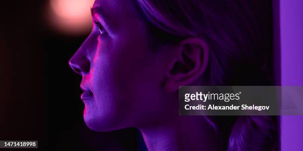 female portrait in neon color indoors, person with purple, blue, red and pink light. woman photo, lifestyle concept photography with multi coloured lights and colors. - red light portrait stock pictures, royalty-free photos & images
