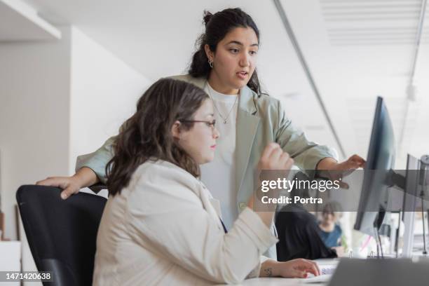 two women working on computer in office - 2 people pointing at computer screen stock pictures, royalty-free photos & images