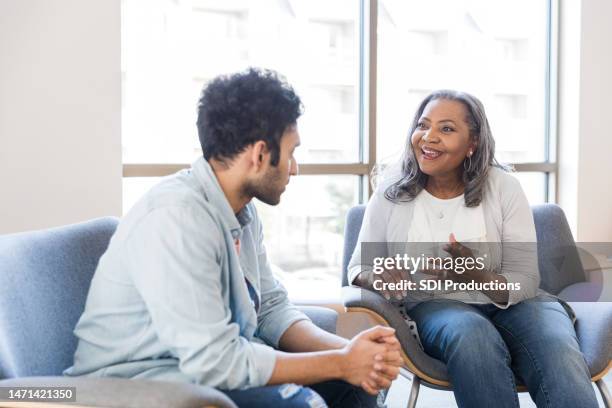 la terapeuta senior è entusiasta dei progressi del giovane uomo - psicoterapeuta foto e immagini stock