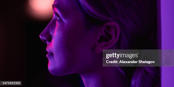 portrait féminin en couleur néon à l’intérieur, personne avec lumière violette, bleue, rouge et rose. photo de femme, photographie concept lifestyle avec lumières et couleurs multicolores. - tube néon photos et images de collection