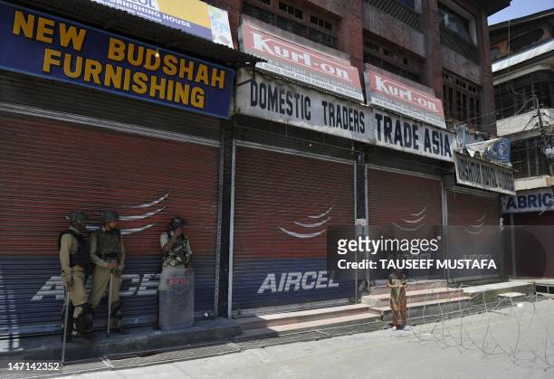 Indian Central Reserve Police Force members patrol a deserted road during an undeclared curfew in downtown Srinagar on June 26, 2012. Parts of...