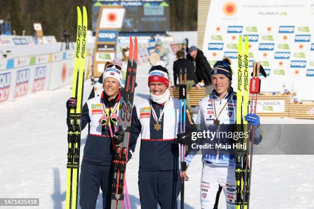 Silver medalist Johannes Hoesflot Klaebo of Norway, gold medalist Paal Golberg of Norway and bronze medalist William Poromaa of Sweden pose for a...