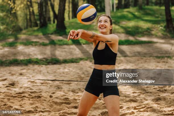 female portrait of woman who playing beach volleyball outdoors. lifestyle sports photography with people. person wear black sports clothing with ball. - beach volleyball bildbanksfoton och bilder