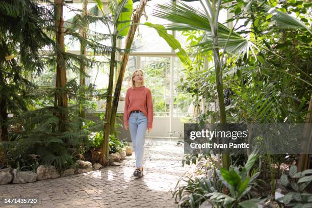 jeunes femmes caucasiennes visitant le jardin botanique local - one young woman only photos et images de collection