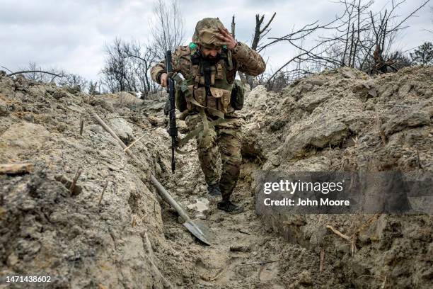 Ukrainian medic "Doc" with the 28th Brigade runs through a partially dug trench along the frontline on March 05, 2023 outside of Bakhmut, Ukraine....