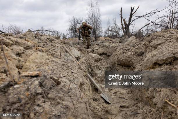 Ukrainian medic "Doc" with the 28th Brigade runs through a partially dug trench along the frontline on March 05, 2023 outside of Bakhmut, Ukraine....