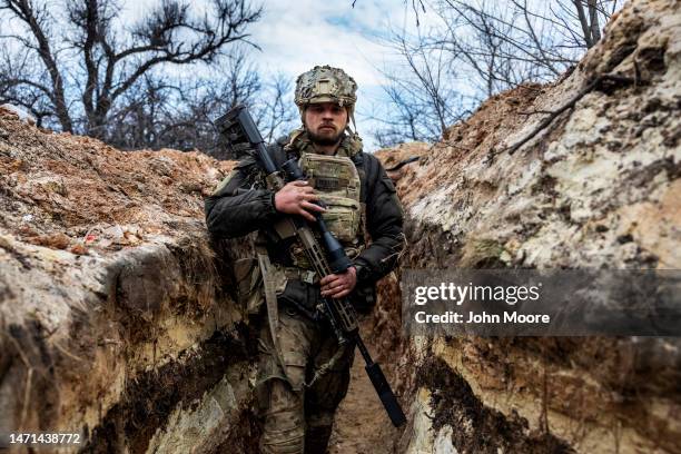 Ukrainian sniper with the 28th Brigade moves to a fighting position in a frontline trench facing Russian troops on March 05, 2023 outside of Bakhmut,...