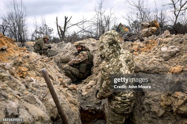 Ukrainian infantrymen with the 28th Brigade take cover in a partially dug trench along the frontline on March 05, 2023 outside of Bakhmut, Ukraine....