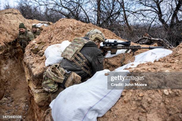 Ukrainian sniper with the 28th Brigade looks towards a Russian position from a frontline trench on March 05, 2023 outside of Bakhmut, Ukraine....