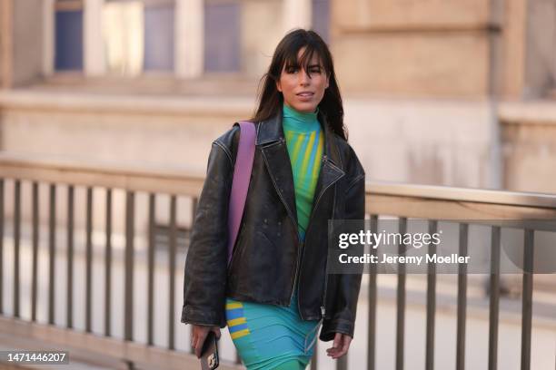 Nina Urgell Cloquell seen wearing a leather jacket, a long tight blue and green patterned dress, a purple bag and black boots before the Nina Ricci...