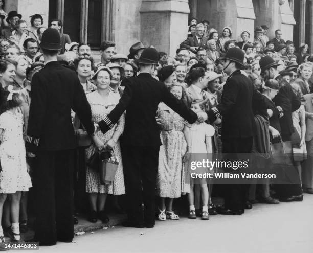 Police officers form a cordon to control a section of spectators during rehearsals for the Coronation procession, ahead of the Coronation of...