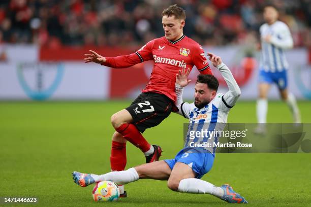 Florian Wirtz of Bayer 04 Leverkusen is challenged by Marco Richter of Hertha Berlin during the Bundesliga match between Bayer 04 Leverkusen and...