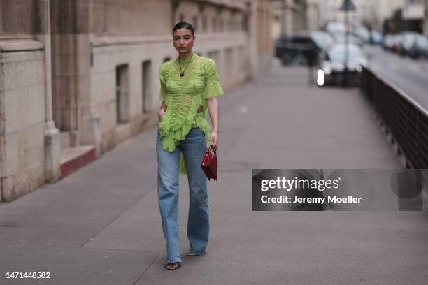 Cassandra Cano seen wearing a green transparent tulle shirt, a red bag by Ester Manas, a jeans and high heels before the Ester Manas show on March...