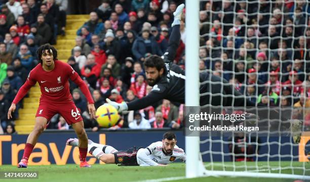 Bruno Fernandes of Manchester United reacts as their shot narrowly misses the post as Trent Alexander-Arnold and Alisson Becker of Liverpool look on...