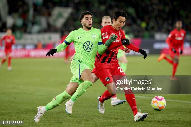 Omar Marmoush of VfL Wolfsburg battles for possession with Makoto Hasebe of Eintracht Frankfurt during the Bundesliga match between VfL Wolfsburg and...