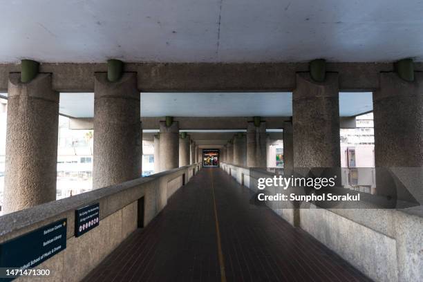 gilbert bridge, an elevated public walkway under gilbert house at night - centro barbican fotografías e imágenes de stock