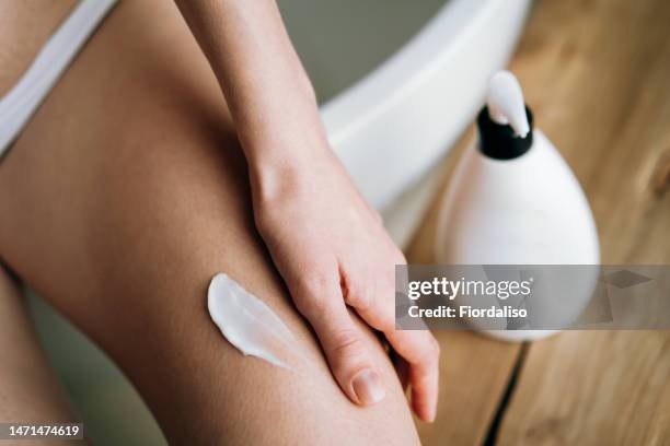 white oily body cream or anti-cellulite scrub, smear of gel on female leg - body scrub stock-fotos und bilder