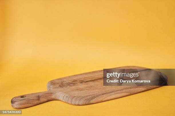 wooden cutting board on the yellow background. mock up for your design. product display for your food product with copy space. - tabla de cortar fotografías e imágenes de stock