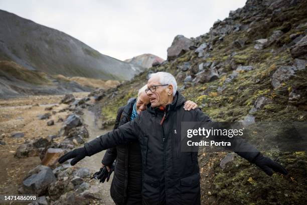 happy senior couple enjoying hiking on volcanic mountain trail - casal-de-verdade imagens e fotografias de stock