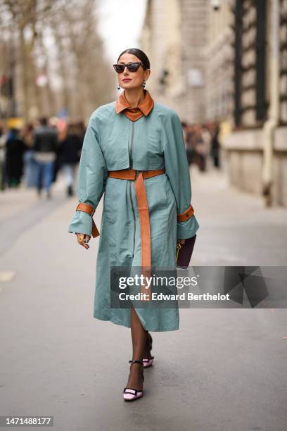 Julia Haghjoo wears black cat eyes sunglasses, a blue green cropped jacket with camel shiny leather borders, a matching blue green midi skirt with...