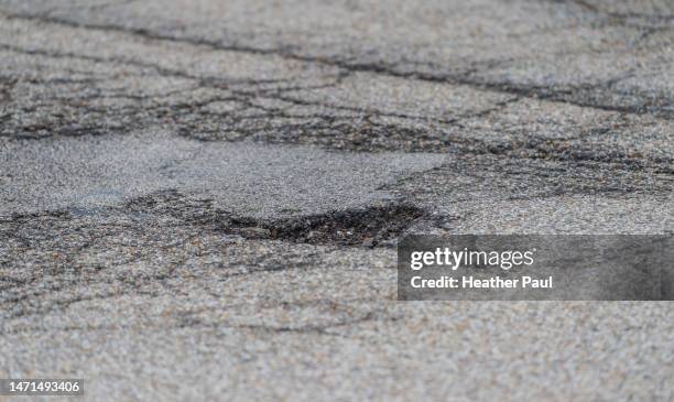 large pothole on a city street - pothole stock-fotos und bilder