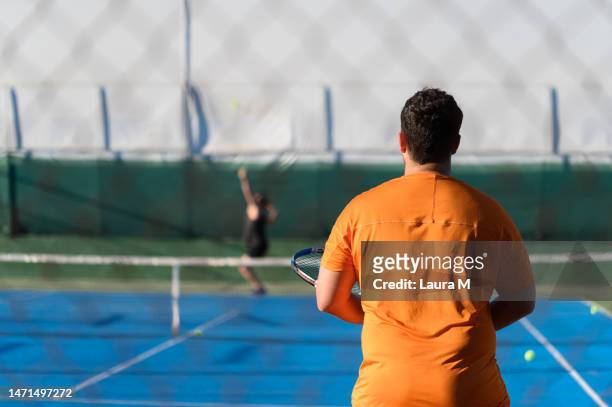 rear view of a man playing tennis with a friend - open round two stock pictures, royalty-free photos & images