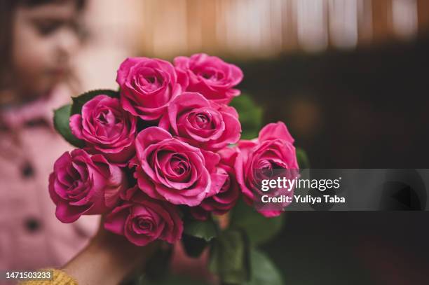 mothers day gift. mother holding flowers from her little daughter. close up. - rose arrangement stock pictures, royalty-free photos & images