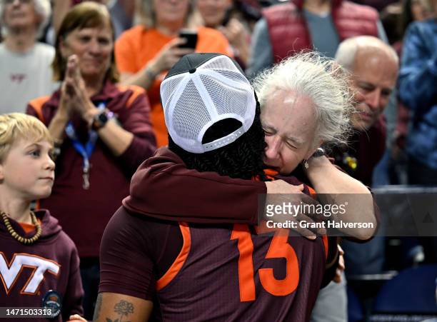 Fan embraces Taylor Soule of the Virginia Tech Hokies as they celebrate a win against the Louisville Cardinals in the ACC Women's Basketball...