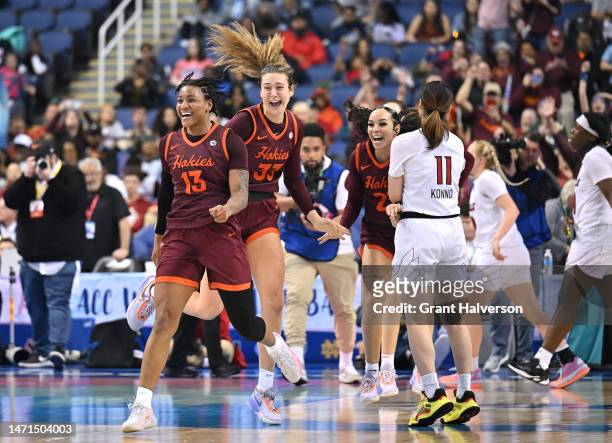 Taylor Soule, Elizabeth Kitley and Kayana Traylor of the Virginia Tech Hokies celebrate as time expires to win against the Louisville Cardinals in...