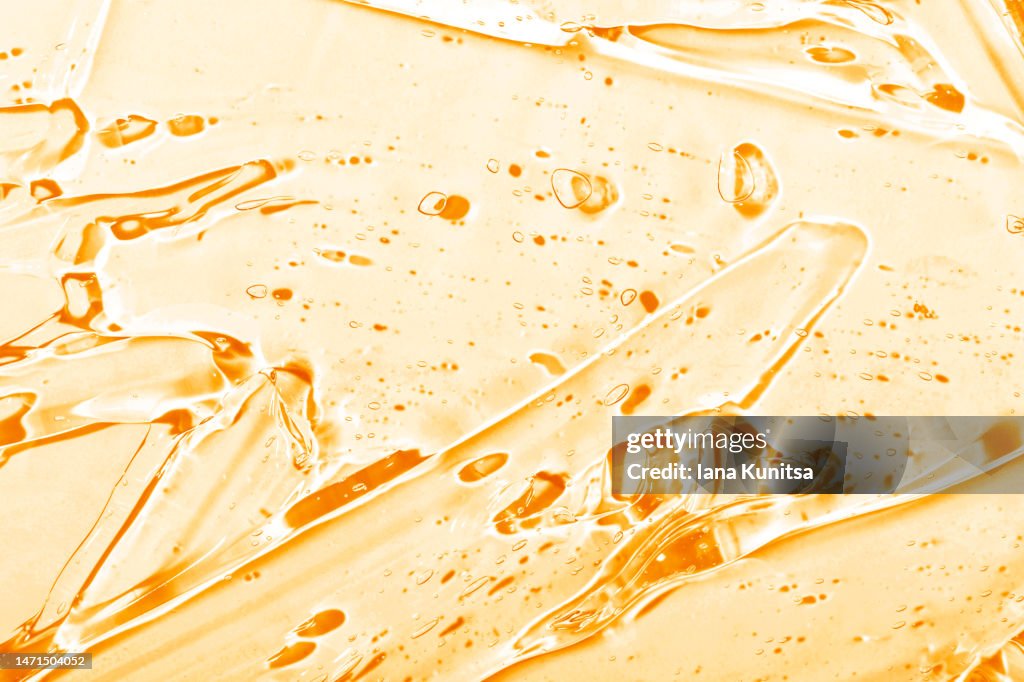 Transparent yellow smudged texture. Vitamin C. Facial serum. Antibacterial gel with bubbles. Cosmetic products for skincare.