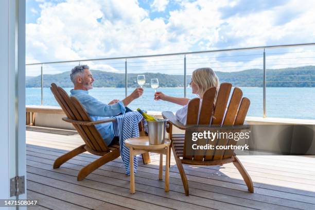 pareja madura bebiendo vino en la cubierta. - capital fotografías e imágenes de stock